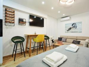 Market Studio by Irundo في زغرب: غرفة معيشة مع أريكة وطاولة وكراسي