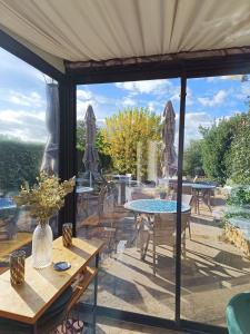 a patio with tables and chairs and a view of a garden at Hôtel La Reconce in Poisson