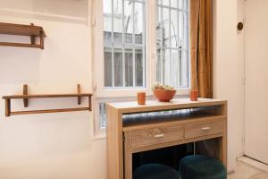 Pokój z oknem i drewnianym stołem w obiekcie Studio avec jacuzzi dans le 10e w Paryżu