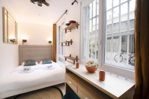 um quarto com uma cama grande e uma janela em Studio avec jacuzzi dans le 10e em Paris