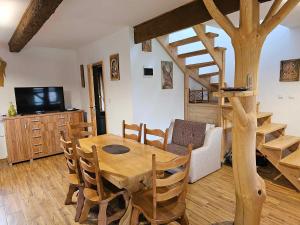 une salle à manger avec une table en bois et un arbre dans l'établissement Serce Beskidu Niskiego Myscowa, à Krempna