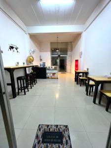 Nong PrueにあるFuture Hostel Pattayaのテーブルと椅子、床に看板が備わる客室です。
