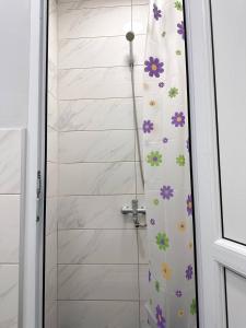 uma cortina de chuveiro com flores na casa de banho em Stay Hostel em Bishkek