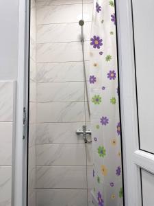 a shower curtain with flowers on it in a bathroom at Stay Hostel in Bishkek