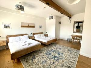 two beds in a room with a rug at The Cart Lodge at Lee Wick Farm Cottages & Glamping in Saint Osyth