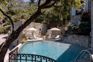 a large swimming pool with chairs and umbrellas at Hôtel Case Latine in Lama