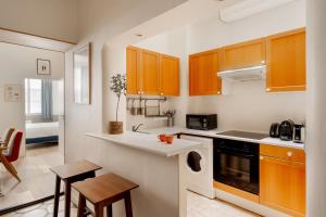 a kitchen with wooden cabinets and a counter top at Edgar Suites Saint-Augustin - Naples in Paris