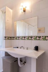 a white bathroom with a sink and a mirror at Gaspar Campos 1204 by depptö in Bella Vista