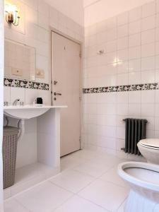 a white bathroom with a toilet and a sink at Gaspar Campos 1204 by depptö in Bella Vista