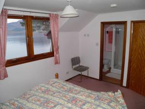 a bedroom with a bed and a window and a chair at Seaview in Glenelg