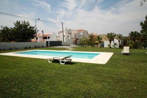 a swimming pool in the yard of a house at Modern Luxury Townhouse 3 Bedroom Townhouse Olhos de Agua Communal pool AT03 in Olhos de Água