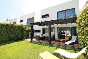 a backyard with chairs and a pergola at Modern Luxury Townhouse 3 Bedroom Townhouse Olhos de Agua Communal pool AT03 in Olhos de Água