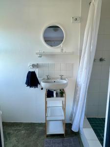 y baño con lavabo y espejo. en Riverdance Cottage, en Malgas