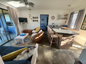 a living room with a couch and a kitchen with a table at Riverdance Cottage in Malgas