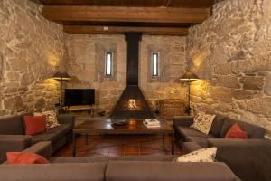 sala de estar con 2 sofás y chimenea en Rectoral de Cobres 1729, en San Adrián de Cobres