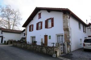 ein weißes Haus mit einem Zaun davor in der Unterkunft Maison "harotcheta" in Saint-Pée-sur-Nivelle