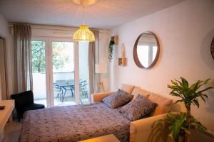 um quarto com uma cama e uma sala de estar em Joli Appart / Parking / CLIM / WIFI em Montpellier