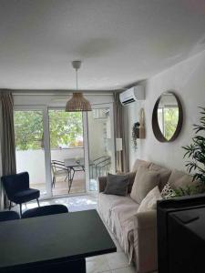 uma sala de estar com um sofá e uma mesa em Joli Appart / Parking / CLIM / WIFI em Montpellier