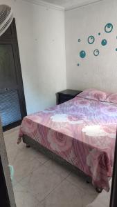 Schlafzimmer mit einem Bett mit rosa Tagesdecke in der Unterkunft Habitaciones El Mirador in Cartagena de Indias