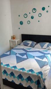 a bedroom with a bed with a blue and white comforter at Habitaciones El Mirador in Cartagena de Indias