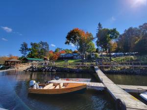 a wooden boat is docked next to a dock at Dayspring Cottages in Emsdale