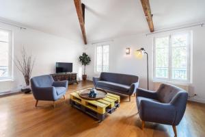 een woonkamer met 2 stoelen en een salontafel bij Loft Paris Expo Porte de Versailles in Malakoff