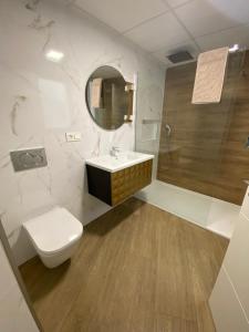 a bathroom with a toilet and a sink and a mirror at Apartamento Isabel in Caravaca de la Cruz