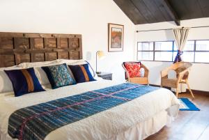 a bedroom with a large bed and two chairs at Villas de la Ermita in Antigua Guatemala +70 photos