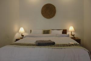 a bedroom with a large bed with two lamps at KAJI HOME in Pātan