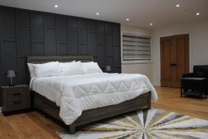 um quarto com uma cama grande e uma parede preta em Where Luxury Retreat meets Convenience! em Tottenham