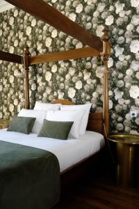 um quarto com uma cama com uma parede floral em Maison Prieuré 