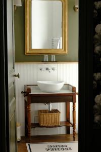 uma casa de banho com um lavatório e um espelho em Maison Prieuré 