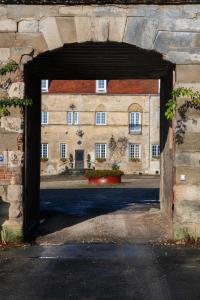 uma entrada para um edifício com um edifício de tijolos em Maison Prieuré 