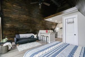 ein Schlafzimmer mit einem Bett und einer Holzwand in der Unterkunft Dean's Den: Private Deck w/ Jacuzzi and a View in New Braunfels