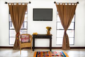 a living room with curtains and a chair and a table at Villas de la Ermita in Antigua Guatemala