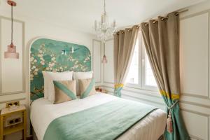 1 dormitorio con 1 cama con cabecero azul en Luxury 3 Bedroom & 3 Bathroom - Champs Elysees & Louvre en París