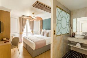 1 dormitorio con 1 cama y baño con lavamanos en Luxury 3 Bedroom & 3 Bathroom - Champs Elysees & Louvre en París