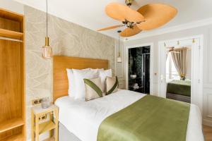 1 dormitorio con 1 cama y ventilador de techo en Luxury 3 Bedroom & 3 Bathroom - Champs Elysees & Louvre en París