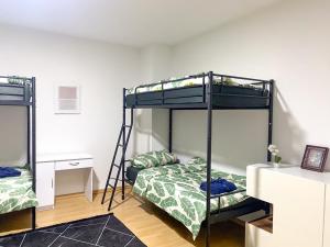 1 dormitorio con 2 literas y escritorio en Shared Serenity accommodation, en Wuppertal