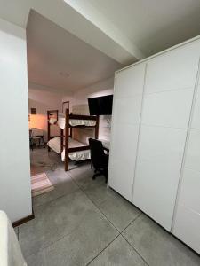 Zimmer mit 2 Etagenbetten und einem Zimmer mit einem Schreibtisch. in der Unterkunft STUDIO 101 | WIFI 600MB | RESIDENCIAL JC, um lugar para ficar. in Belém