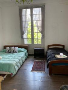 a bedroom with two beds and a window at Edificio Quijano in Montevideo