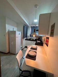 a kitchen with a table with two plates on it at STUDIO 101 | WIFI 600MB | RESIDENCIAL JC, um lugar para ficar. in Belém