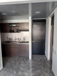 cocina con puerta negra en una habitación en Apartamento Vacacional Familiar en Girardot, piscinas, Jacuzis, parqueadero privado, en Girardot