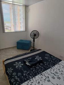 a bedroom with a bed with a black and white blanket at Apartamento Vacacional Familiar en Girardot, piscinas, Jacuzis, parqueadero privado in Girardot