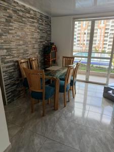 a dining room with a table and chairs and windows at Apartamento Vacacional Familiar en Girardot, piscinas, Jacuzis, parqueadero privado in Girardot