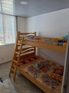 two bunk beds in a room with a ladder at Apartamento Vacacional Familiar en Girardot, piscinas, Jacuzis, parqueadero privado in Girardot