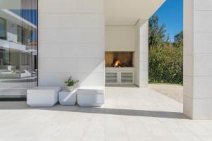 un patio con chimenea en una casa en Villa Vrsar Magnifique A Beautiful Contemporary 5 Bedroom Villa Sauna and Gym, en Vrsar