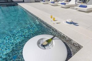 una botella de vino en un bol junto a la piscina en Villa Vrsar Magnifique A Beautiful Contemporary 5 Bedroom Villa Sauna and Gym, en Vrsar