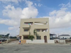 un edificio blanco alto frente a un estacionamiento en Top floor 1 bdrm aprtrmnt, en Mor Menekshe