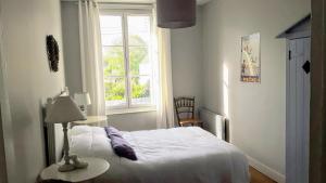 een slaapkamer met een bed en een raam bij Le Cottage de la Plage - 2ch, 2 SDB - Terrasse - Déco de charme - 500m plage in Cabourg
